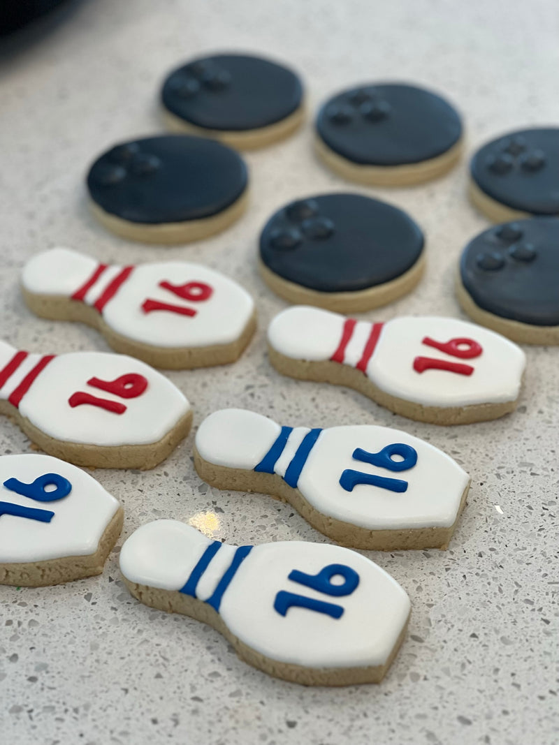 Bowling pin cookies with numbers on a gray surface